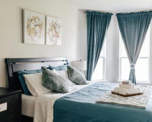 a bedroom with a blue bed with pillows and a window at Luxury Lovely Comfort house in San Antonio