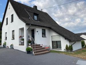 una casa blanca con techo negro en Kleine Auszeit, Schöne neue Ferienwohnung, en Bitburg