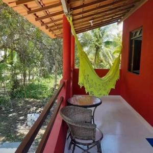 a balcony with a table and chairs on a house at Axé Mainha Flats! Quarta Praia! in Morro de São Paulo