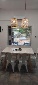 a white dining room table with chairs and two lights at Nuestra Casa en Paso in Paso de la Patria