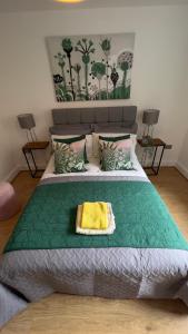 ein Schlafzimmer mit einem großen Bett und einer grünen Decke in der Unterkunft The Church View, Great for Contractors and groups, Easy access M1 in Markyatestreet