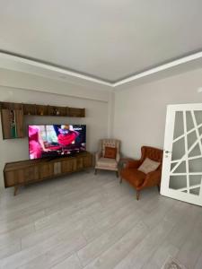 ein Wohnzimmer mit einem Flachbild-TV und 2 Stühlen in der Unterkunft Two bedroom Apartment in Center Antalya near Shopping Center MarkAntalya in Antalya