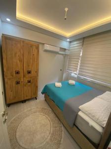 ein Schlafzimmer mit einem blauen Bett und einem Fenster in der Unterkunft Two bedroom Apartment in Center Antalya near Shopping Center MarkAntalya in Antalya