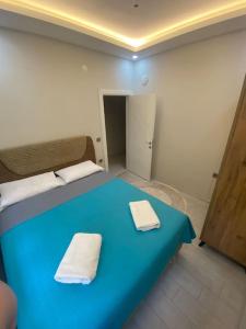 ein blaues Bett in einem Zimmer mit zwei Handtüchern darauf in der Unterkunft Two bedroom Apartment in Center Antalya near Shopping Center MarkAntalya in Antalya
