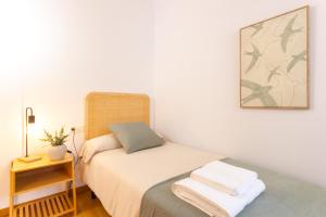 a small bedroom with a bed and a night stand at Elegante dúplex en Terrassa, Barcelona in Terrassa