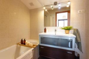 a bathroom with a sink and a tub and a mirror at Elegante dúplex en Terrassa, Barcelona in Terrassa +21 photos