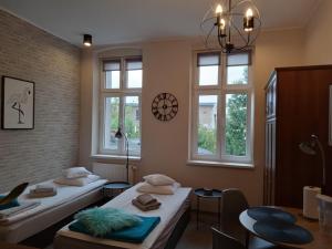 a room with two beds and two windows at Przytulne studio w centrum Starego Miasta in Bydgoszcz