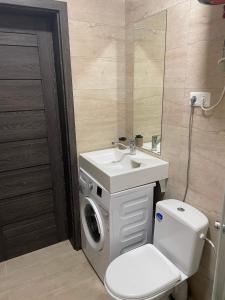 a bathroom with a washing machine and a sink at Apartamentai in Raseiniai