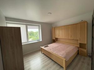 Ένα ή περισσότερα κρεβάτια σε δωμάτιο στο Apartamentai
