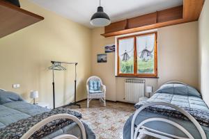una camera da letto con due letti e una finestra di Sole E Lago - Iseo View - by HOST4U a Riva di Solto