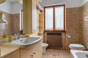 un bagno con lavandino, water e finestra di Sole E Lago - Iseo View - by HOST4U a Riva di Solto