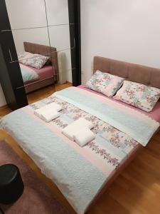 a bedroom with two beds with pillows and a mirror at Zlatibor apartman Boki in Ocka Gora