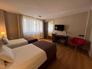 um quarto de hotel com duas camas e uma secretária em Bue Hotel em Buenos Aires