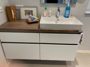 eine Badezimmertheke mit Waschbecken und einem weißen Waschbecken in der Unterkunft Kleine Auszeit, Schöne neue Ferienwohnung in Bitburg + 16 Fotos