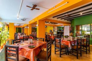 a restaurant with tables and chairs in a room at Calangute Beachside Apartment by Welkin stays in Calangute