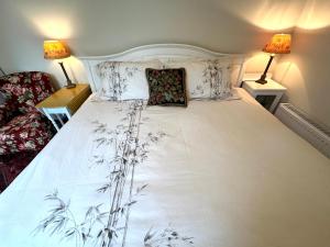 un grande letto bianco con due cuscini sopra di Garden Snug a Belfast