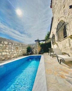 a swimming pool in front of a stone building at Windy Inns ( Maistros I ) in Vouyiáton