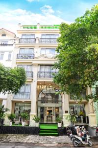 a large white building with a scooter parked in front of it at Warm Ways Hotel & Serviced Apartments in Ho Chi Minh City