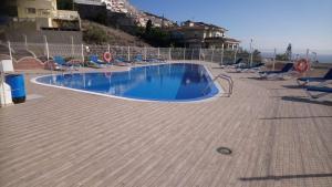 a swimming pool with chairs around it on a patio at 16 Sunset view in Adeje +5 photos