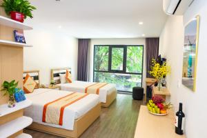 a hotel room with two beds and a window at Warm Ways Hotel & Serviced Apartments in Ho Chi Minh City