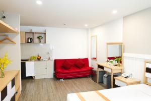 a red couch in a room with a kitchen at Warm Ways Hotel & Serviced Apartments in Ho Chi Minh City