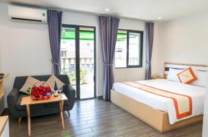 a bedroom with a bed and a couch and a table at Warm Ways Hotel & Serviced Apartments in Ho Chi Minh City