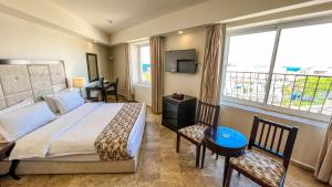 a bedroom with a bed and a large window at Yafko Hotel in Aqaba