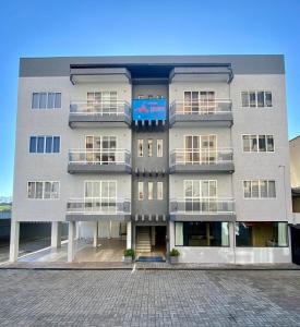 a large gray building with balconies on a street at Pousada das Águas in Piratuba