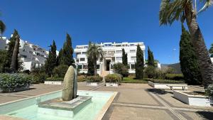 a large white building with a statue in front of it at Vitania Resort La Cala Apartment in Málaga