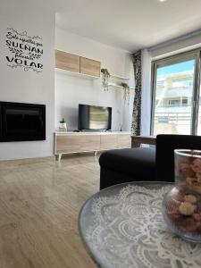 a living room with a tv and a table at Vitania Resort La Cala Apartment in Málaga
