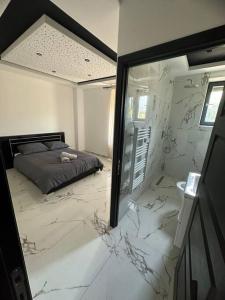 a bedroom with white marble floors and a bed at Appartement T3 Terrasse 