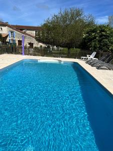 a large blue swimming pool in a yard at Le Petit Bijou in Saint-Fraigne