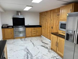 cocina grande con suelo de mármol y armarios de madera en Bijou Apartment in Spanish Point, en Spanish Point