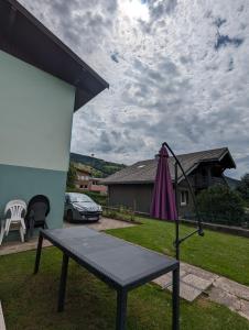 a ping pong table and an umbrella in a yard at Gite 'chez Cocotte' in La Bresse