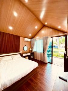 um quarto com uma cama e uma grande janela em Hồ Cốc Park & Resort em Xã Như Lâm