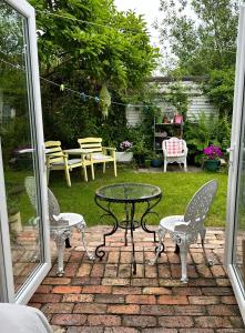 a patio with a table and chairs and a yard at Garden Snug in Belfast