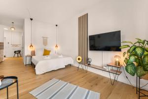 1 dormitorio con 1 cama y TV grande en la pared en Modernes Apartment im Kaiserkiez, en Oldenburg
