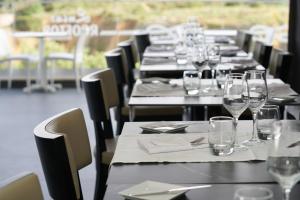 a row of tables with wine glasses and napkins at Carvi Beach Hotel in Lagos