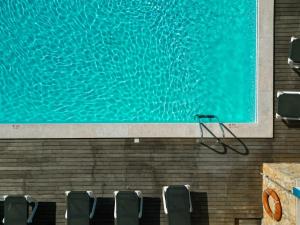 a swimming pool with chairs next to a large painting at Carvi Beach Hotel in Lagos