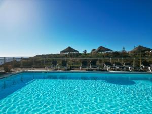 a large swimming pool with chairs and umbrellas at Carvi Beach Hotel in Lagos