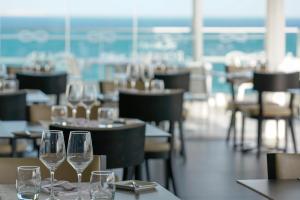 a row of wine glasses sitting on tables in a restaurant at Carvi Beach Hotel in Lagos