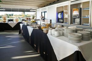 a buffet line with white plates and dishes on it at Carvi Beach Hotel in Lagos