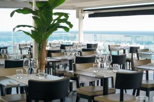 a restaurant with tables and chairs and a plant at Carvi Beach Hotel in Lagos
