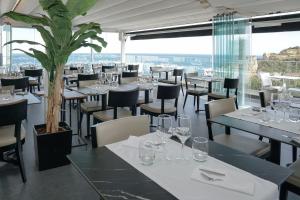 a restaurant with tables and chairs and a potted plant at Carvi Beach Hotel in Lagos