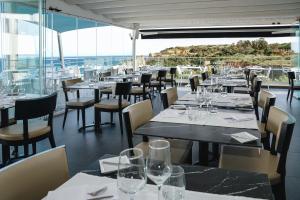 a restaurant with tables and chairs with a view of the ocean at Carvi Beach Hotel in Lagos