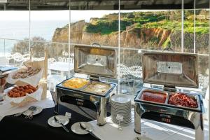two bbqs with food in front of a window at Carvi Beach Hotel in Lagos