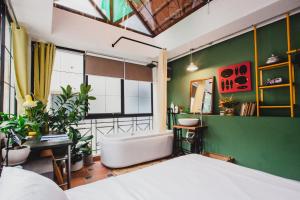 1 dormitorio con cama y pared verde en The Watch Tower, en Ho Chi Minh