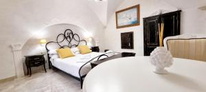 Palazzo Castiglione في غالّيبولي: غرفة نوم بسرير ابيض كبير وطاولة