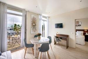 un salon avec une table et des chaises ainsi qu'une chambre dans l'établissement Hotel du Vieux Port, à Saint-Raphaël