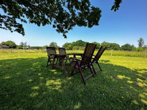 three chairs and a picnic table in the grass at Holly Hill Apartments in Southampton